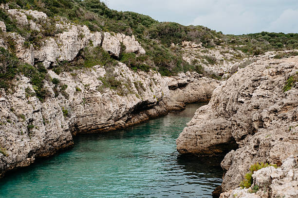 Rocky cliffs and turquoise waters of Cala en Brut, Menorca in Ciutadella de Menorca, Balearic Islands, Spain