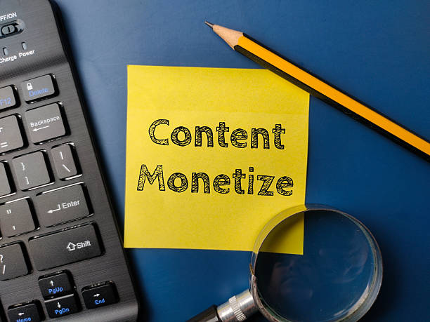 istock Black keyboard and magnifying glass with the word Content Monetize on a yellow sticky note 2213815535