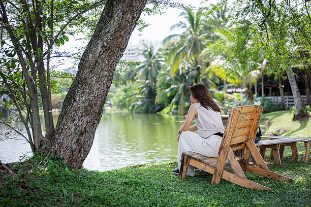 A busy businesswoman relaxing by the lakeside, finding peace after work or during a lunch break.