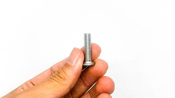 istock A stainless steel flat head screw held by a man's hand. 2213821411