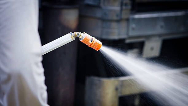 Closeup of a misting nozzle spraying disinfectant to sanitize entry before accessing poultry facility, showing biosecurity measures and hygiene protocols in modern indoor livestock farming systems.
