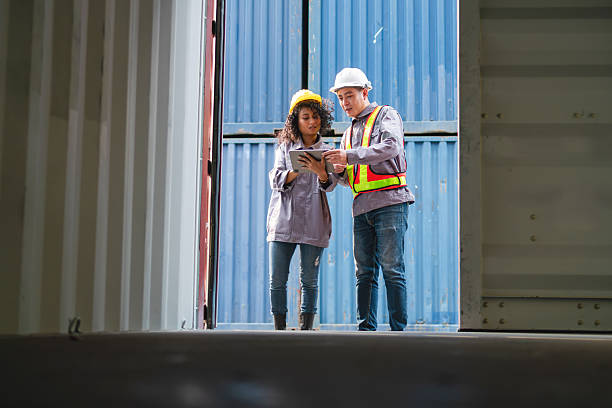 istock Engineer and Foreman Team in Safety Gear Inspecting Containers Box at Industrial Site, Container Yard Dock Workers Discussion at Shipping Yard 2213832509