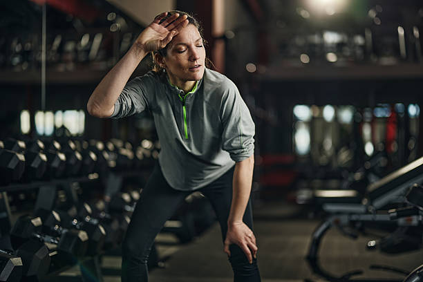 istock Exhausted athletic woman taking a break in a gym. 2213832675