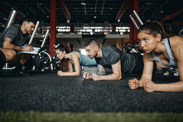 istock Athletic people doing planks on sports training with their coach. 2213833834