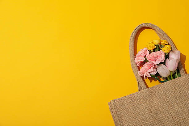 istock Flowers in bag on yellow background, space for text 2213834473