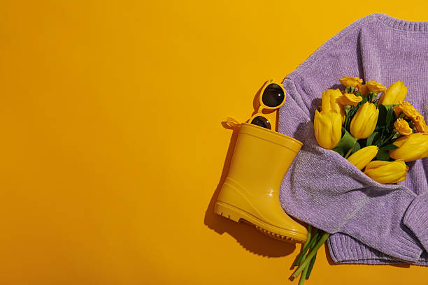 istock Sweater, flowers, sunglasses and rubber boot on yellow background, space for text 2213834738