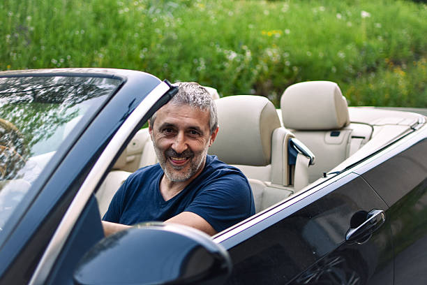 istock a middle-aged man sits in a convertible 2213835630