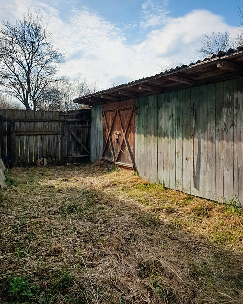 Empty backyard at night with green grass and wood fence