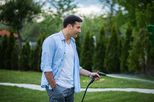 istock Man watering his garden with a hose 2213836069