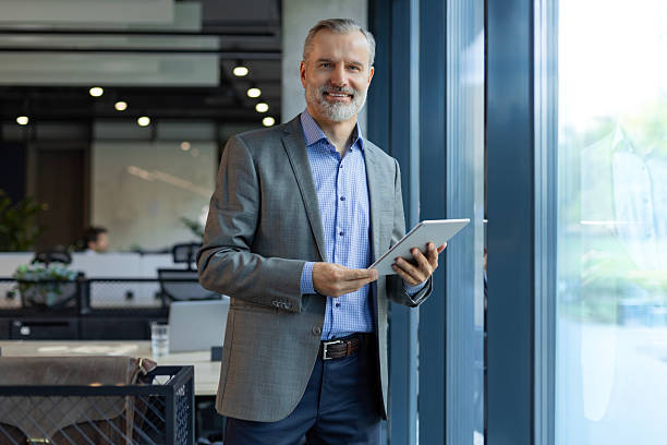 istock Smiling handsome businessman manager standing in office with tablet computer 2213837757