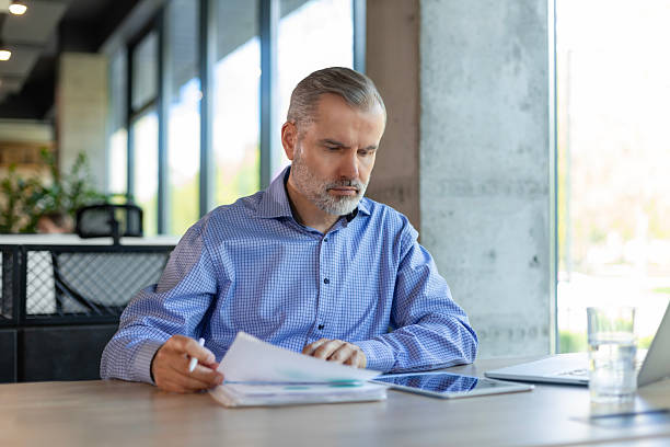 istock Smiling handsome mature businessman manager working office with documents 2213837956