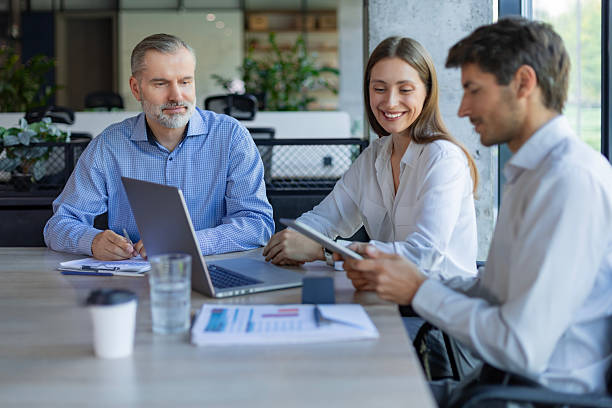 istock Successful businesspeople working in a coworking space working with laptop discussing strategy and business plan in modern office. 2213838307