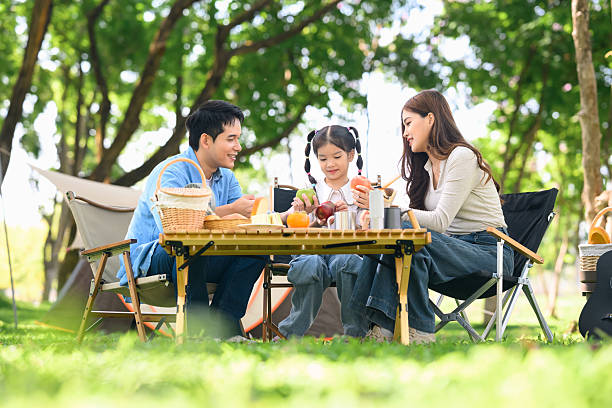 istock Happy family enjoying breakfast at a table while camping in a forest park 2213838827