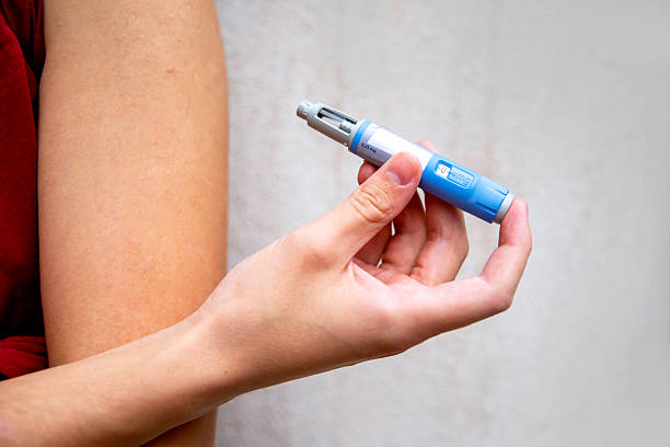Young Man giving insulin injection in his arm