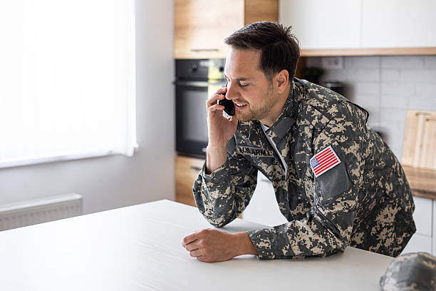 istock Soldier in military uniform talking on phone in kitchen 2213851328