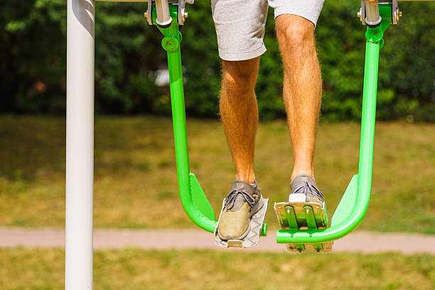 Working out in outdoor gym. Male doing legs exercises on street simulators. Staying fit and healthy.