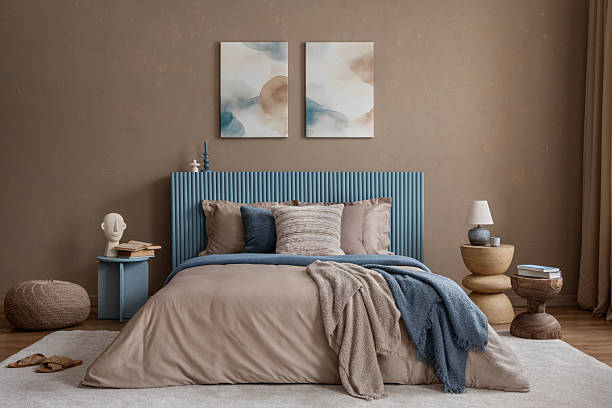 istock A cozy bedroom with a ribbed blue headboard, layered textiles, and abstract wall art in soft, earthy tones. 2213852015
