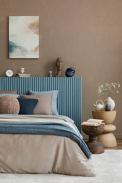 istock A serene bedroom setting with neutral bedding, textured pillows, and a warm-toned background, creating a tranquil atmosphere. 2213852038