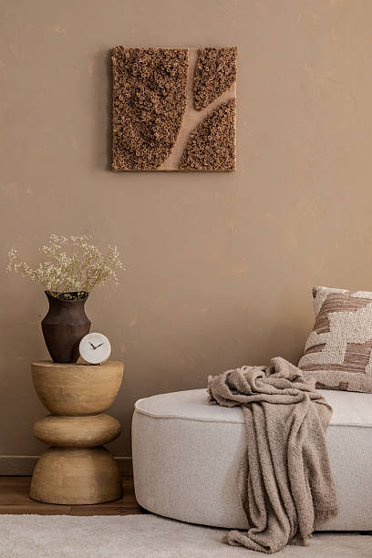 istock Stylish corner with wall art, wooden side table, ceramic clock, and soft textiles in earthy tones. 2213853457