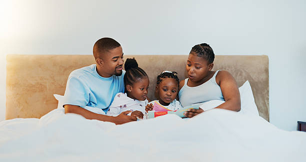 istock Parents, kids and reading book in bedroom for storytelling, language development and bonding. Black family, children and fantasy story for education, literacy learning and listening to novel at house 2213853600