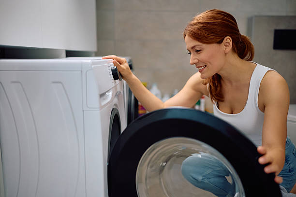 istock Smiling woman feeling satisfied with her new washing machine. 2213853848