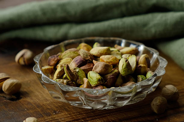 Roasted peeled salted pistachios nuts in plate on table