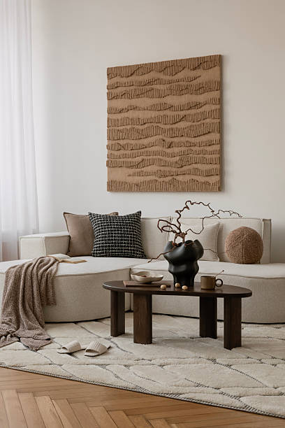 istock Cozy reading corner with soft textures, sculptural vase, and modern black coffee table in a neutral-toned room. 2213855148