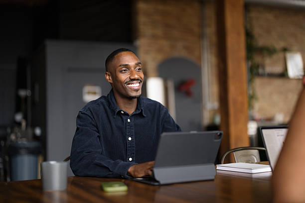 Thoughtful black businessman working on touchpad in the office.