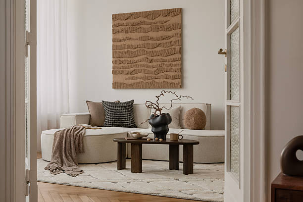 istock Earthy modern interior with round sofa, minimal coffee table, and large textured wall art in a soft natural palette. 2213855178