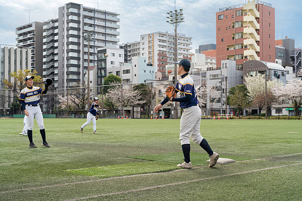 istock Local Baseball Team Practicing in Tokyo Urban Field Surrounded by Blooming Trees 2213855934