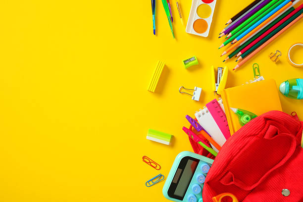 istock Back to school essentials: vibrant stationery and red backpack on yellow background 2213857050
