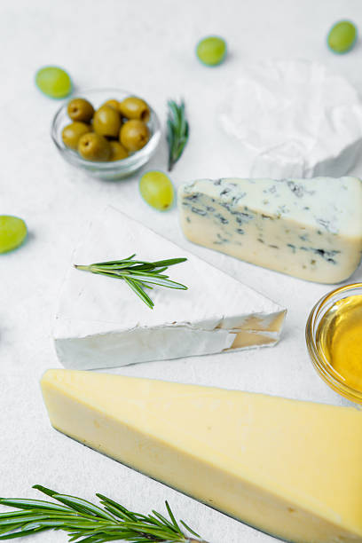 istock Cheese platter with olives, grapes, and honey on a white background 2213857191