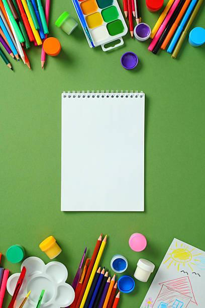 istock Blank paper notebook, paints, and pencils for creativity on a green background. 2213857254