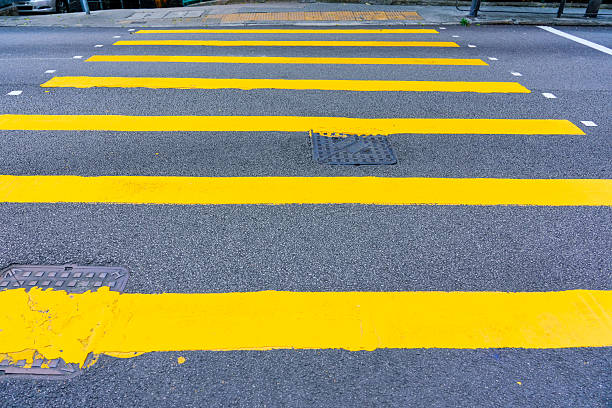 istock Yellow stripes embossed on asphalt in a metropolis pedestrian crossing 2213857663