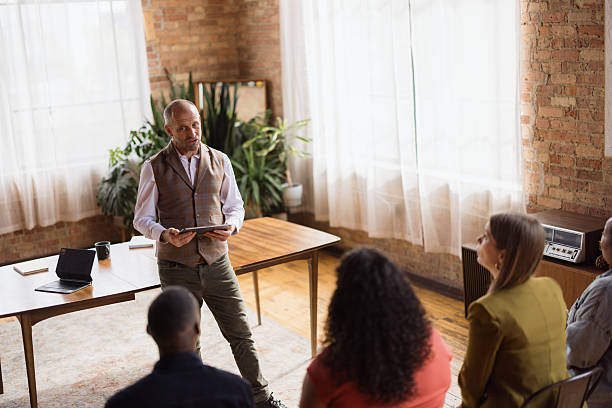 istock Senior businessman using touchpad while leading a seminar in the office. 2213858572