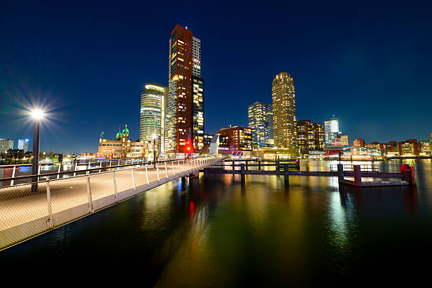 Rotterdam evening view on the Kop van Zuid at the Rijnhaven. Various buildings stand tall in the night including the old Hotel New York, the World Port Center, Montevideo and New Orleans buildings. The name \