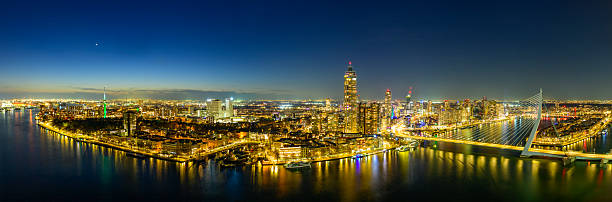 Rotterdam nighttime skyline panorama view from a height at the Nieuwe Maas with the Erasmusbrug and the Zalmhaven. The bridge, often referred to as the \
