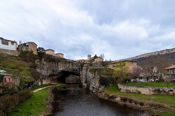istock Puentedey, spain: natural bridge supporting village and flowing river 2213861360