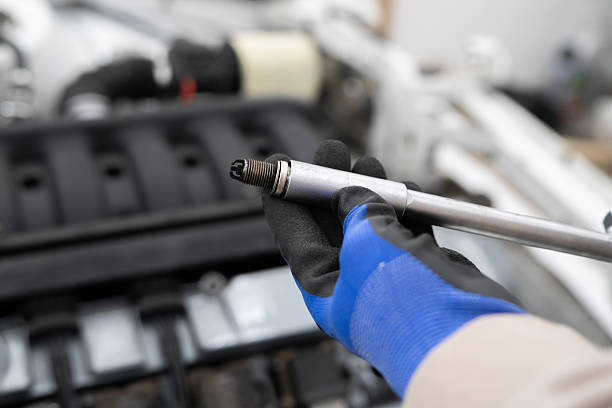 istock Car Mechanic Utilizes Spark Plug Wrench for Efficient Engine Maintenance in a Professional Workshop Setting 2213863404