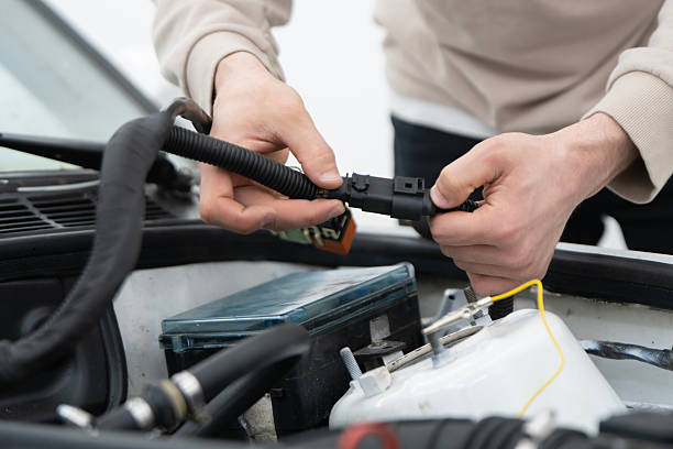 istock Mechanic Connects Car Wire Harness Connectors While Servicing a Vehicle Engine in a Workshop Setting 2213863459
