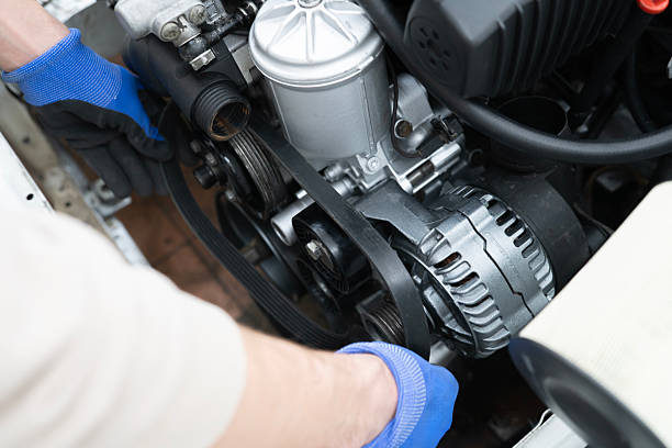 istock Mechanic Working on Car Timing Belt Replacement Under the Hood in Automotive Workshop 2213863575