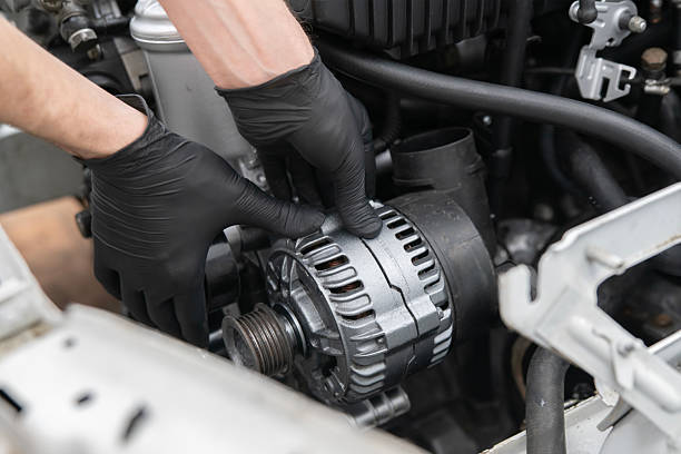 istock Car Mechanic Installs Generator in an Engine Compartment During Service at an Auto workshop 2213863602
