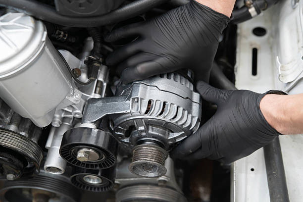 istock Car Mechanic Installs Generator in an Engine Compartment During Service at an Auto workshop 2213863621