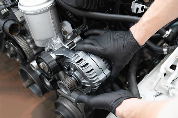 Car Mechanic Installs Generator in an Engine Compartment During Service at an Auto workshop