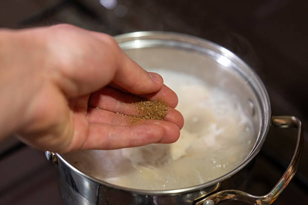 istock Steaming dumplings in a pot while adding pepper for flavor enhancement 2213870074