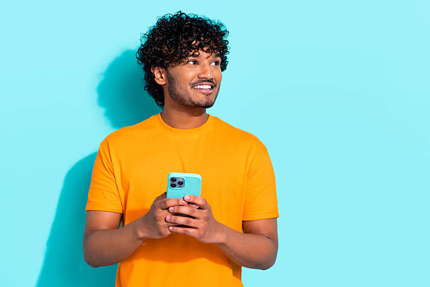 istock Portrait of minded handsome guy hold smart phone look empty space advert brainstorming isolated on turquoise color background 2213871027