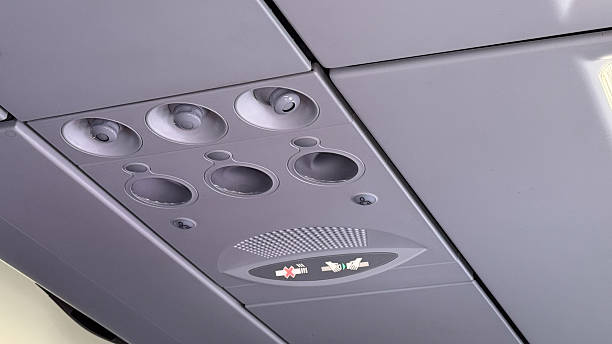 istock Overhead aircraft control panel showing circular vents and illuminated seatbelt and no smoking signs 2213871277