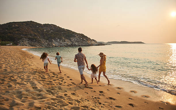istock A family run hand in hand down a tropical paradise beach during sunset 2213872285