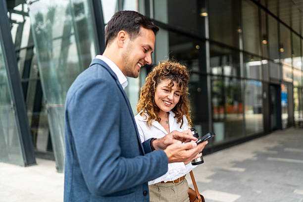 istock Businesspeople using mobile phone outside office building 2213873560