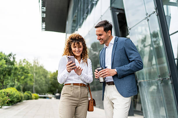 istock Businesspeople walking and using smartphone near office building 2213873831